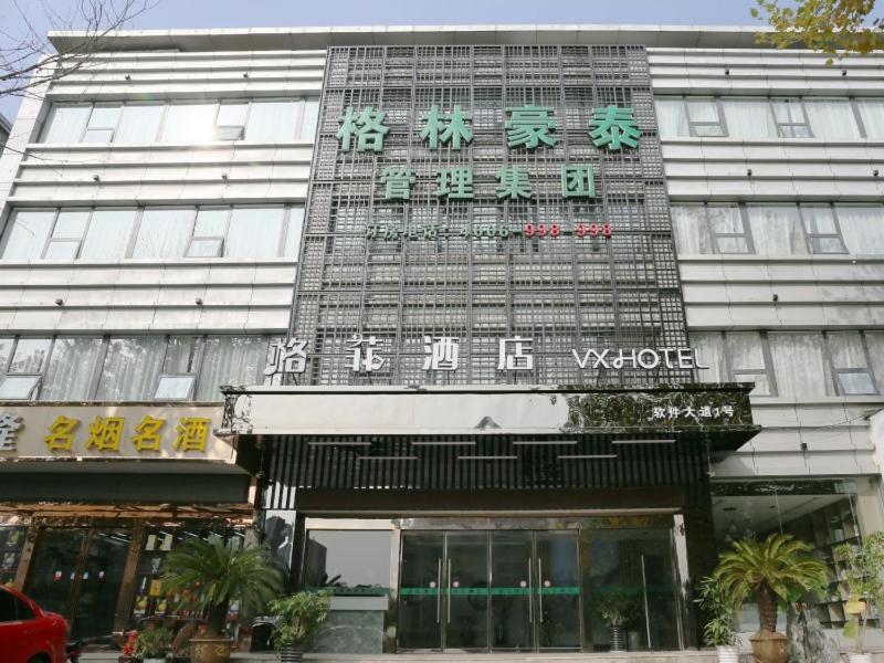 南京VX hotel Nanjing South Railway Station Daming Road Metro Station的前面有标志的建筑