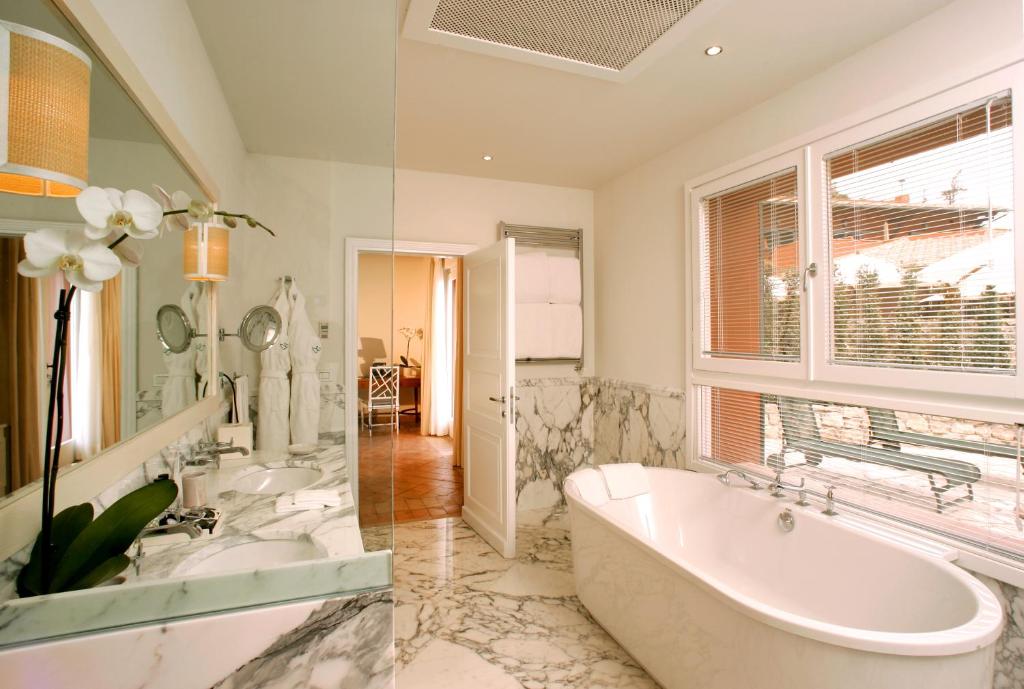 波尔图·埃尔科莱佩里卡诺酒店的带浴缸、两个盥洗盆和窗户的浴室