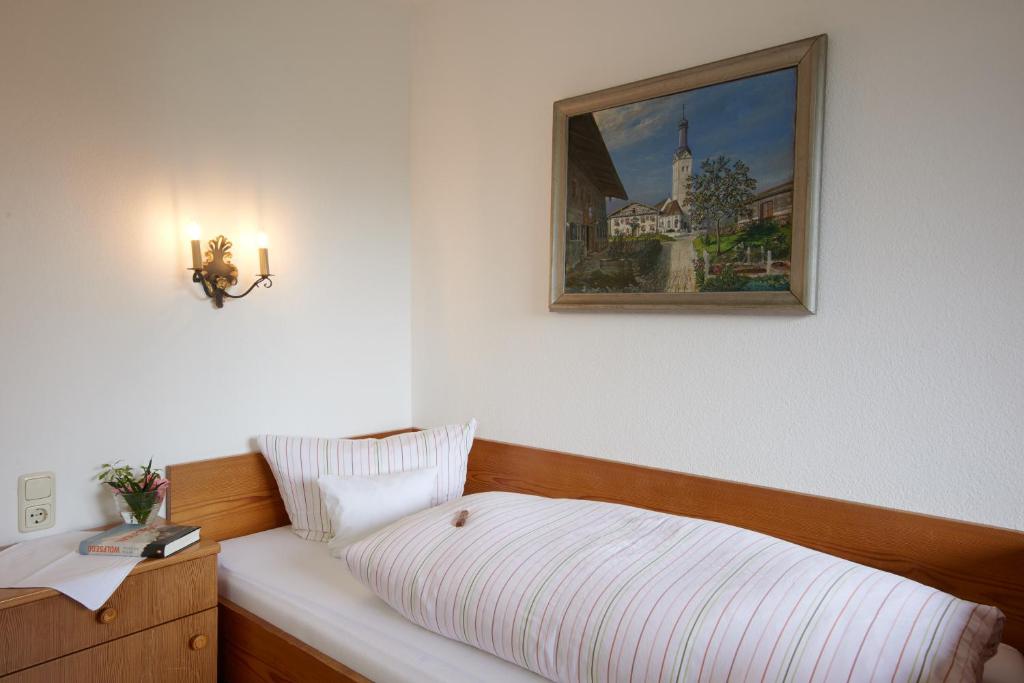 巴特恩多夫爱特布如娜酒店的卧室配有一张床,墙上挂着一幅画
