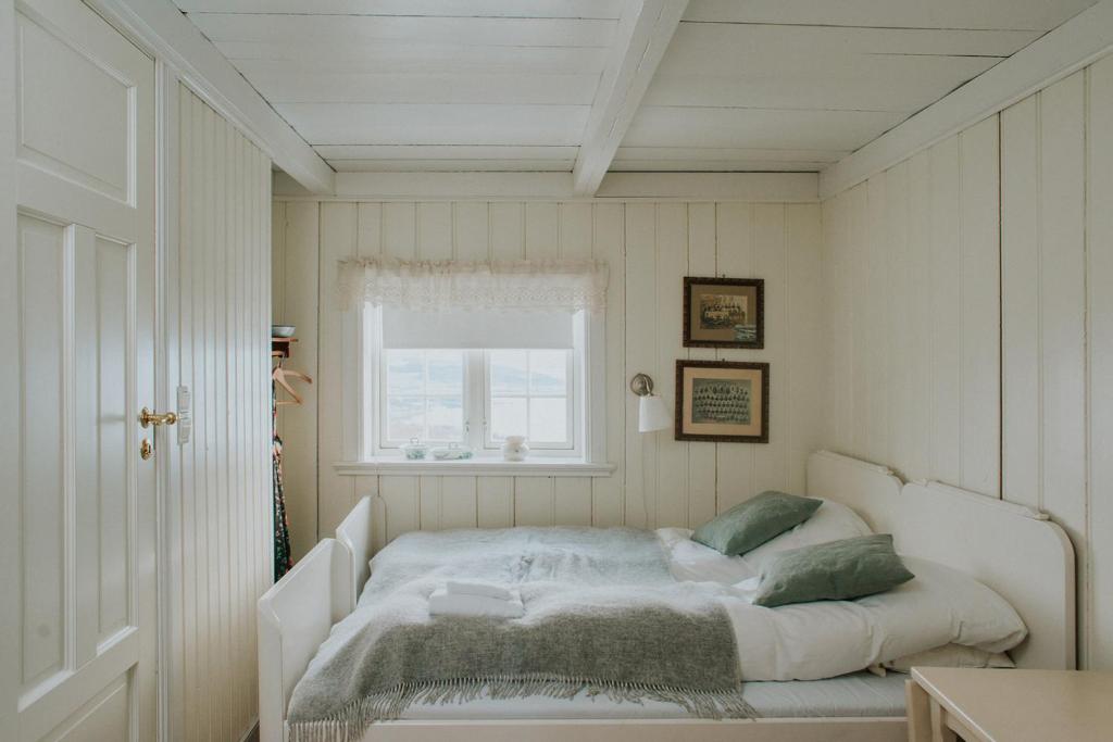 StraumenHusfrua Gårdshotell的窗户客房内的一张白色床