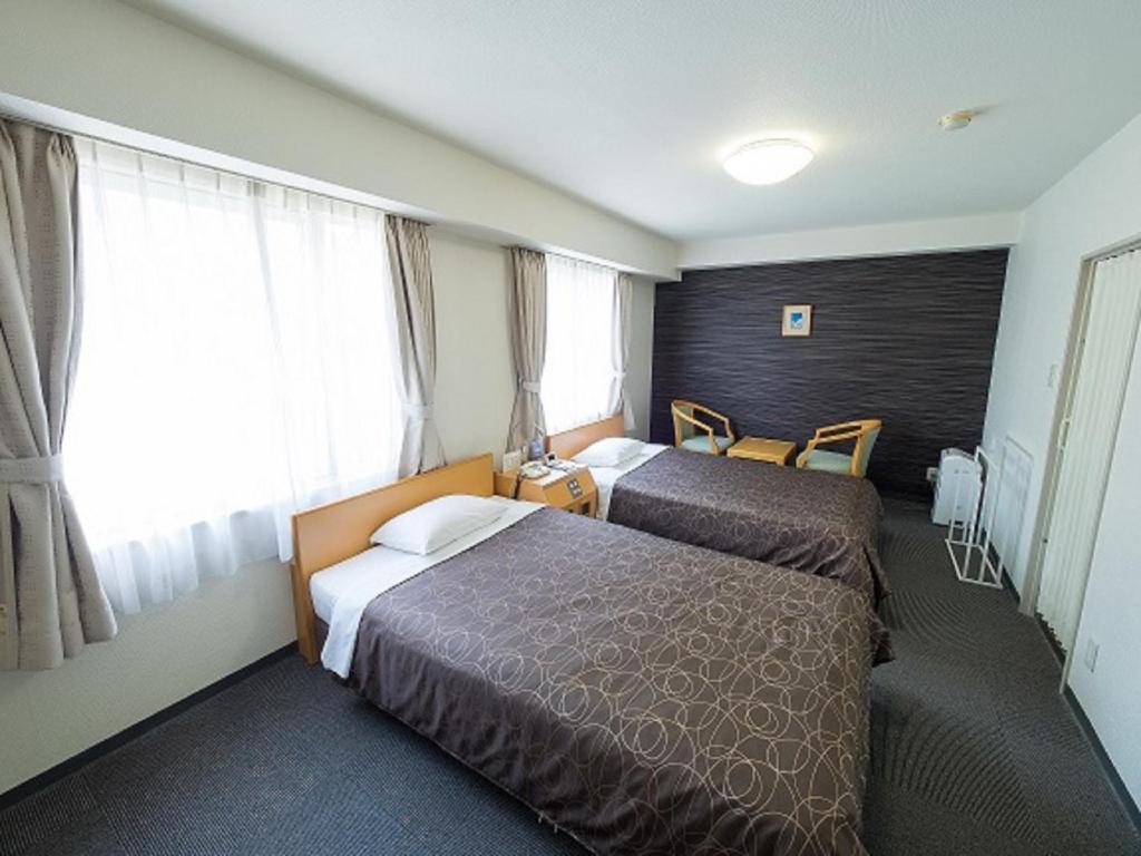 大阪Hotel Shin Osaka / Vacation STAY 81542的酒店客房设有两张床和窗户。