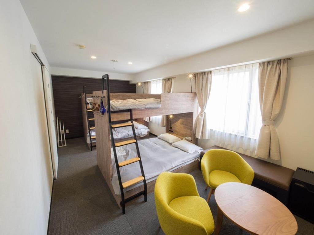 大阪Hotel Shin Osaka / Vacation STAY 81530的客房设有两张双层床和一张桌子及椅子。