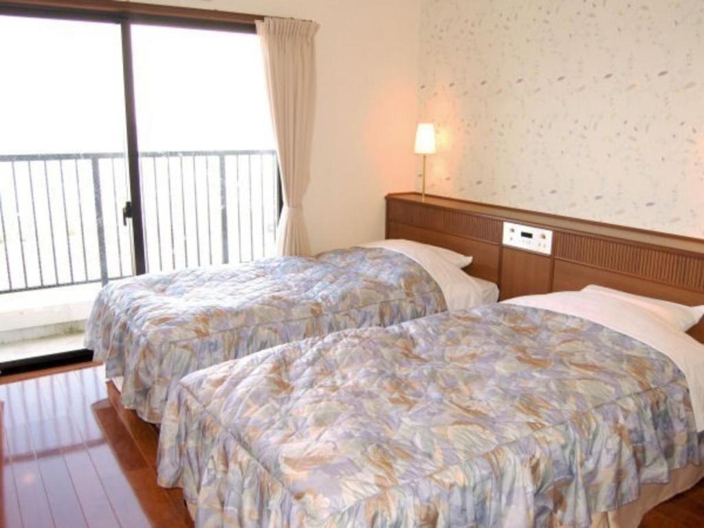 奄美Amami Resort Bashayamamura / Vacation STAY 81475的酒店客房设有两张床和窗户。