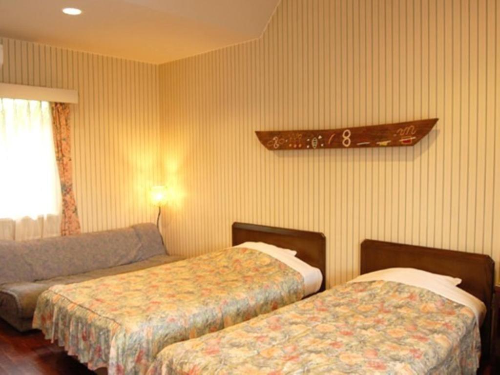 奄美Amami Resort Bashayamamura / Vacation STAY 81477的酒店客房,设有两张床和一张沙发