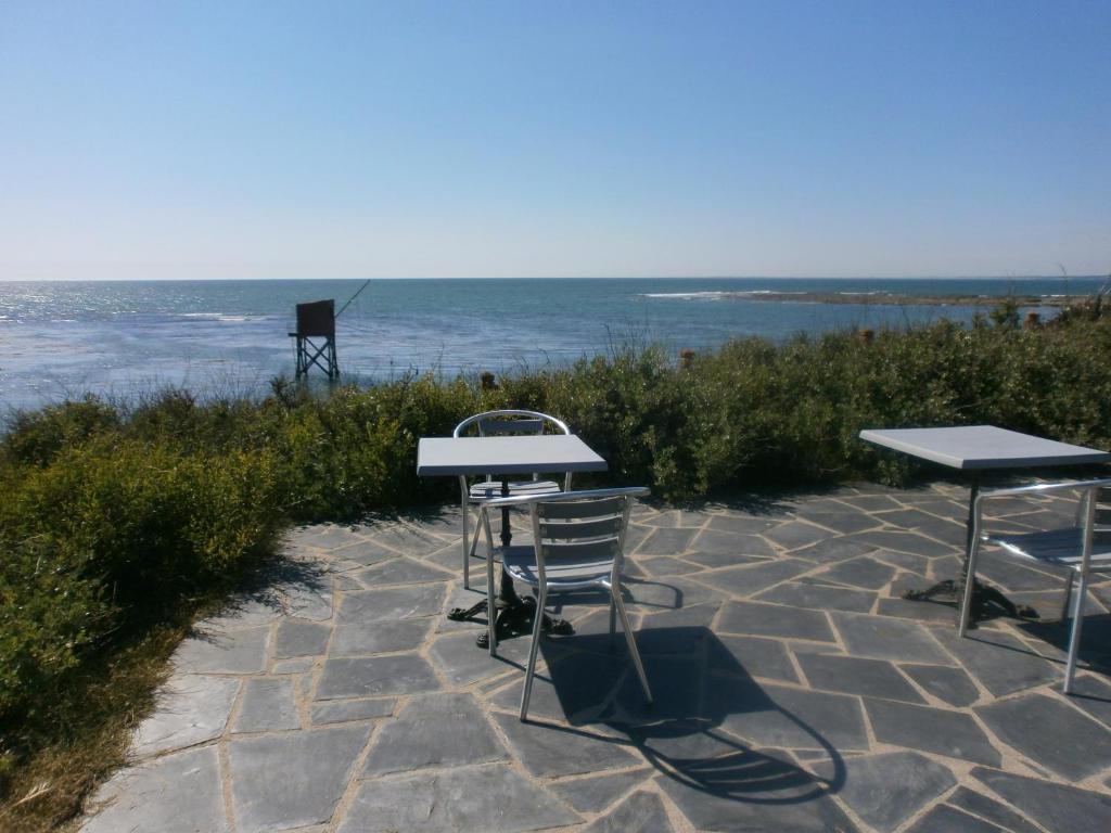 滨海拉普兰bord de mer的两把桌子和椅子坐在靠近大海的石头庭院