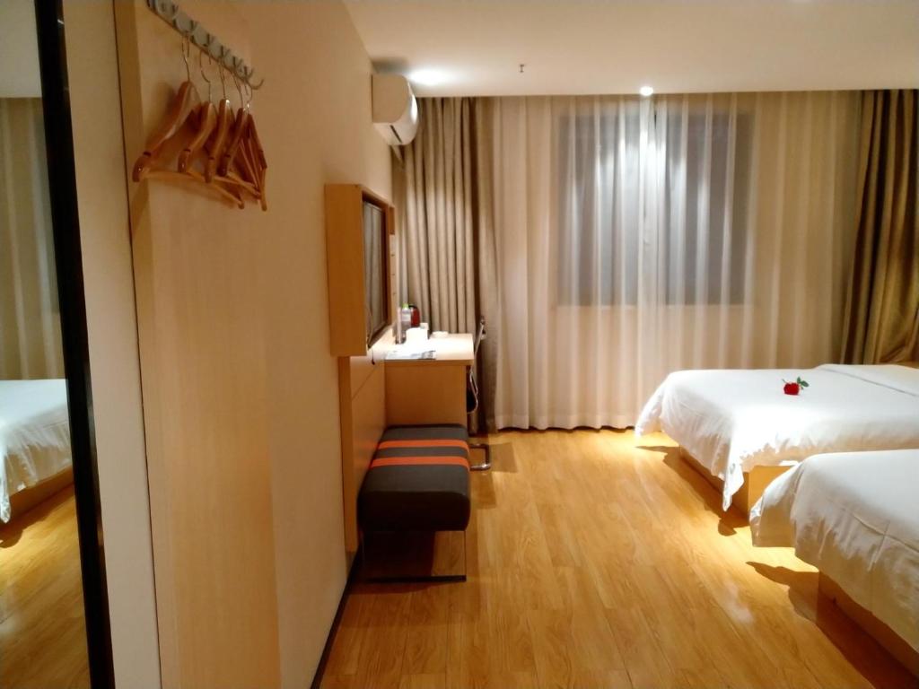 綦江区7天优品.重庆綦江区政府店的酒店客房配有两张床和一张带镜子的书桌