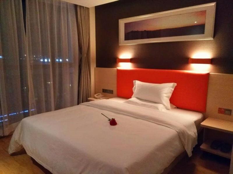 重庆7天优品重庆两江新区鱼复工业园鱼嘴店的一间卧室配有一张白色大床和红色床头板