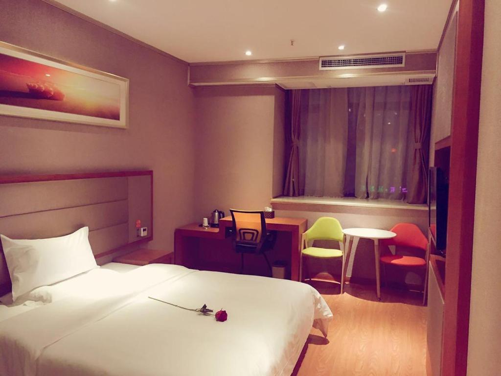 重庆7天优品·重庆汽博中心金童路轻轨站店的酒店客房带一张床、一张桌子和椅子