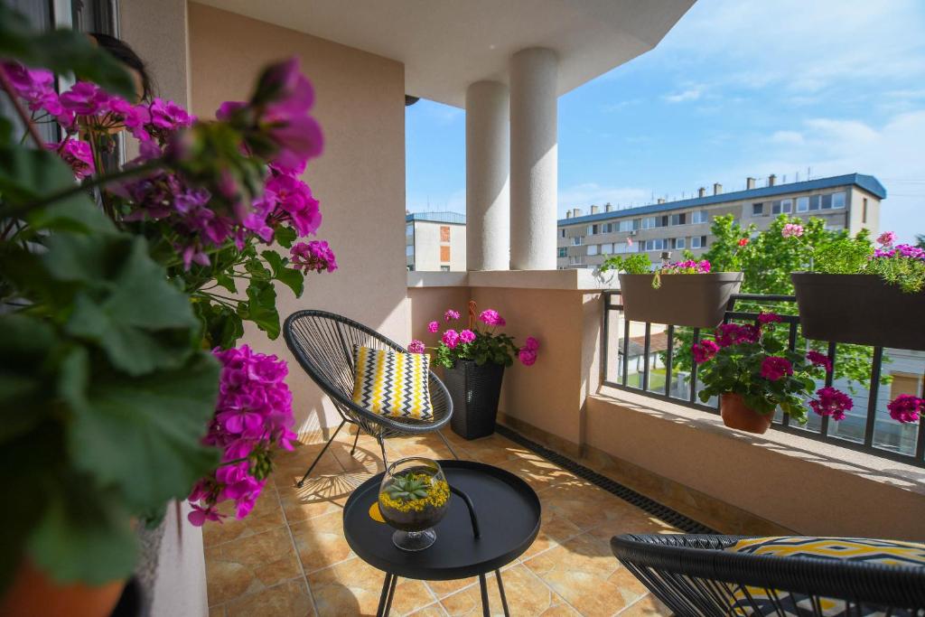 克拉多沃Apartment Plaža的阳台配有桌椅和鲜花。