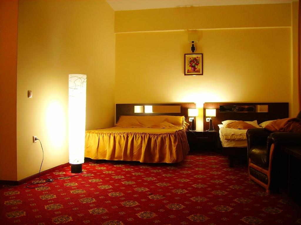 皮特什蒂Hotel Magic GT Trivale的酒店客房,设有两张床,铺有红地毯。
