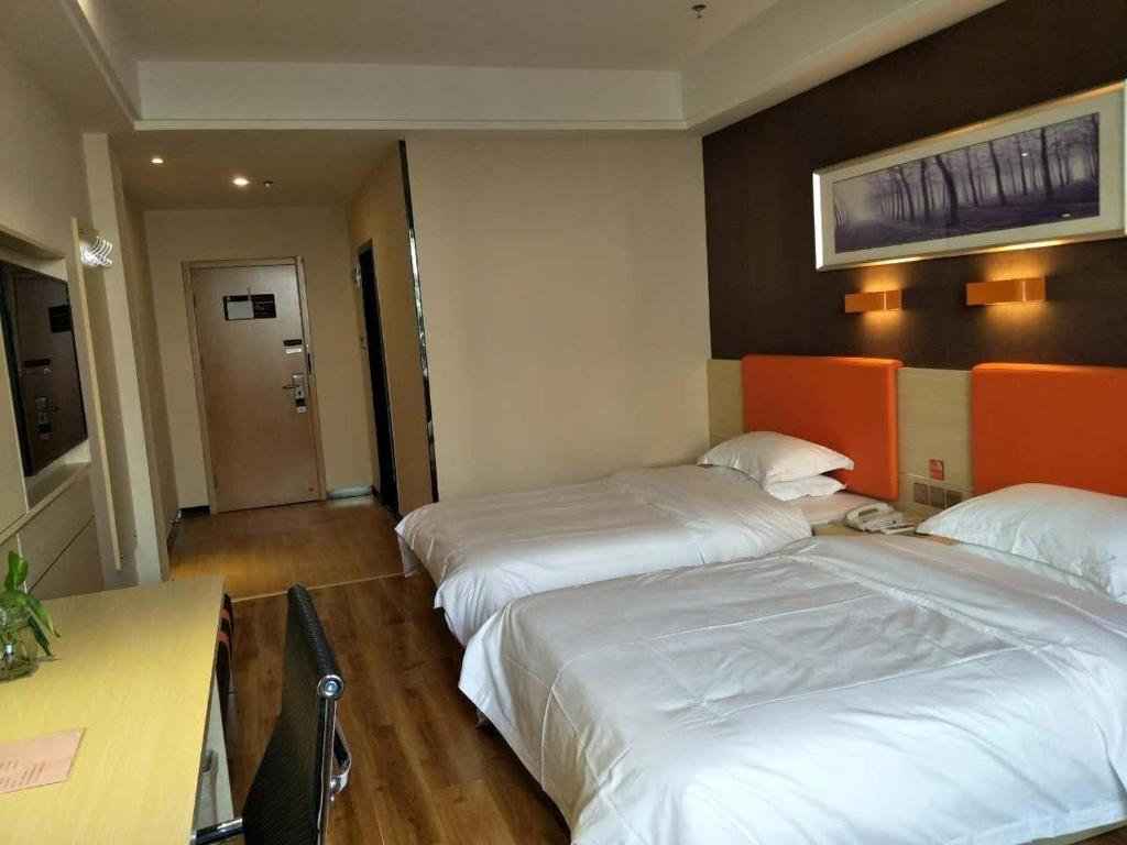 Kipekyüzi7天优品·伊宁上海城店的酒店客房配有两张床和一张书桌