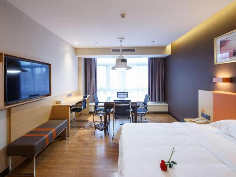 Liangping7天优品·重庆梁平人民广场中心店的酒店客房带两张床和一张桌子以及椅子。