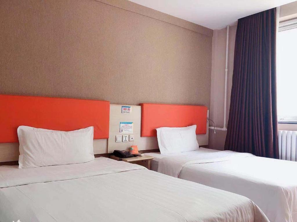 北京7天优品北京中关村人民大学苏州街地铁站店的酒店客房设有两张床和窗户。