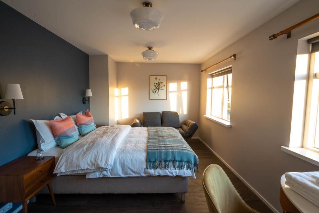FljotSoti Lodge的卧室配有一张床、一张书桌和窗户。