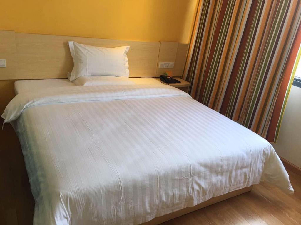 T'ung-jen7天酒店·铜仁江口梵净山国家公园店的窗户客房内的一张白色床