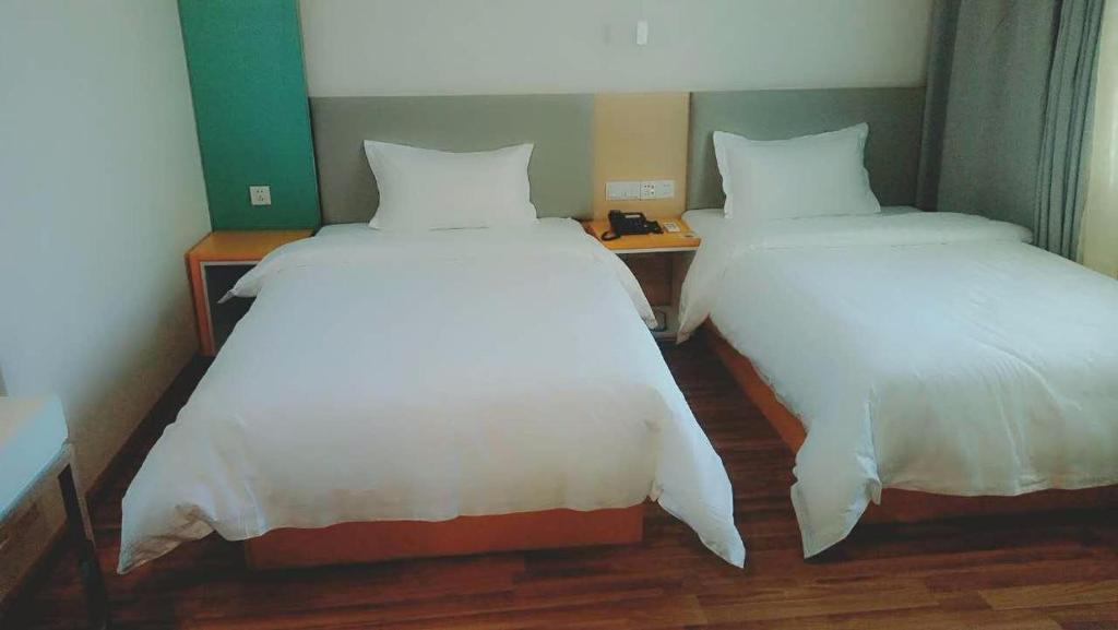 乌鲁木齐7天酒店·乌鲁木齐米东中路神华矿务局店的两张睡床彼此相邻,位于一个房间里