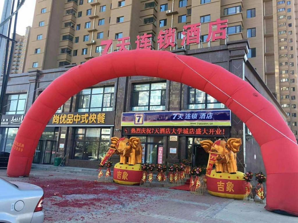葫芦岛7天酒店葫芦岛兴城大学城店的大楼前的红色大拱门