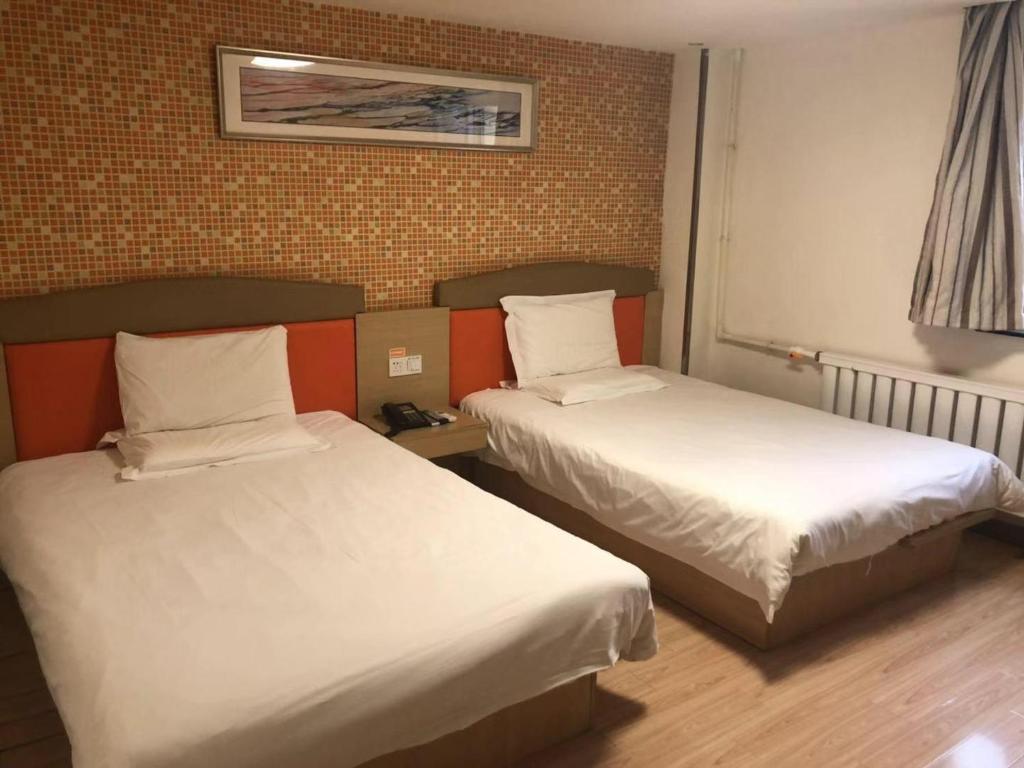 沈阳7天酒店· 沈阳火车站中山广场店的酒店客房带两张床和一面墙