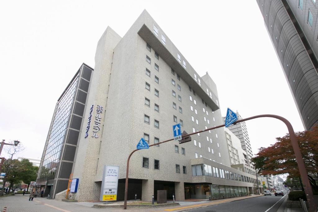 广岛广岛和平公园经济型酒店的一座白色的大建筑,上面有蓝色的标志