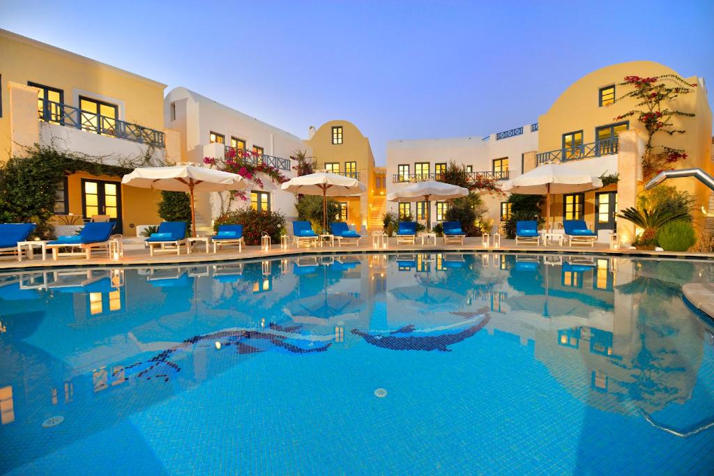 卡马利塔马瑞克斯德尔麦套房酒店的一座带椅子和遮阳伞的大型游泳池