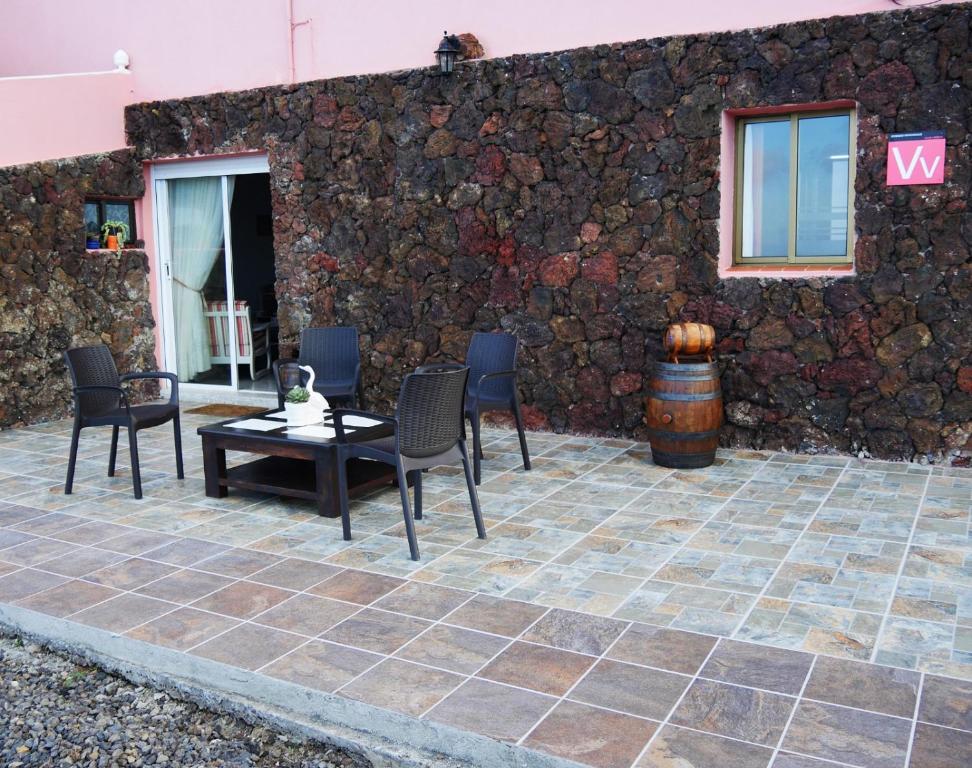EchedoAPARTAMENTO LOS CACTUS的一个带桌椅的庭院和石墙