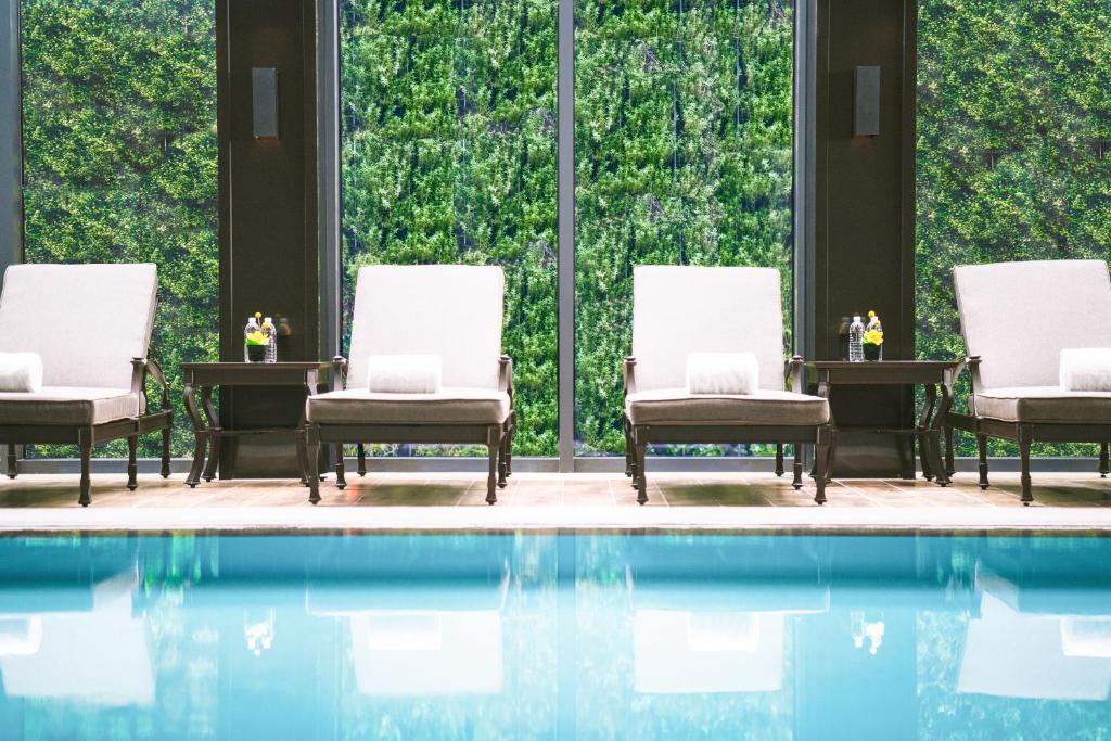 上海上海静安铂尔曼酒店的一组椅子坐在游泳池旁