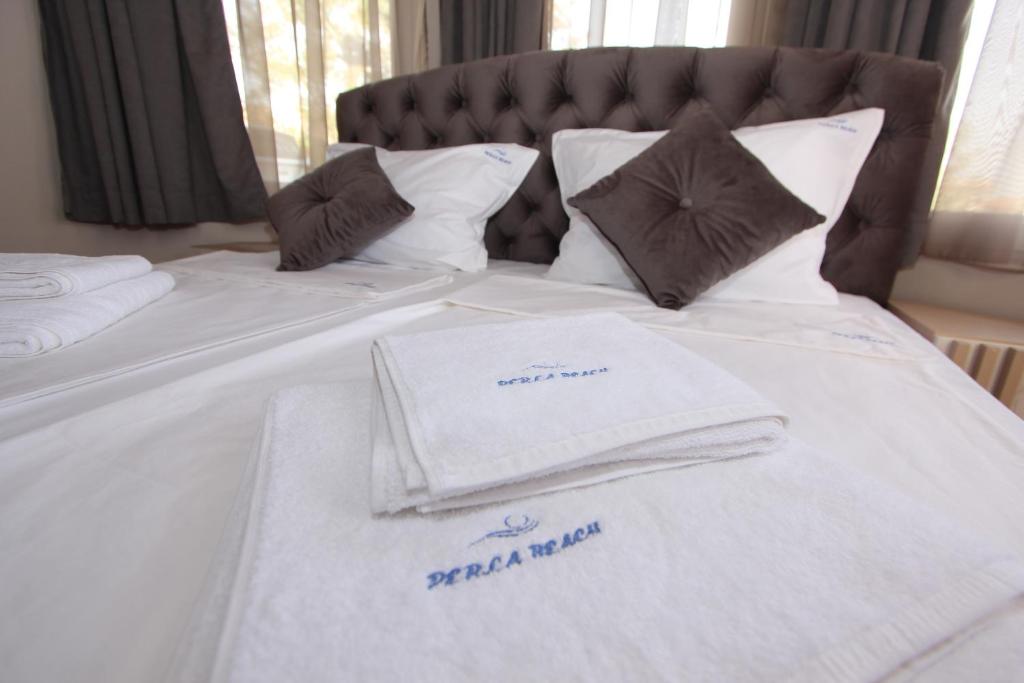 索佐波尔PERLA BEACH的一张带毛巾和枕头的白色床