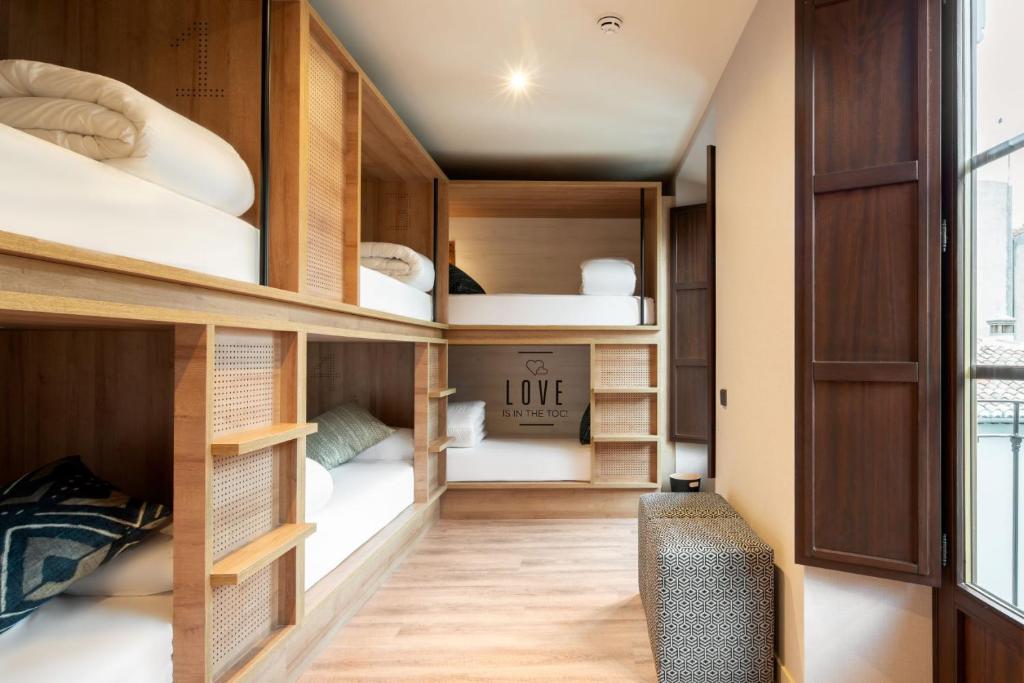 格拉纳达Toc Hostel Granada的客房设有一张木制双层床和沙发