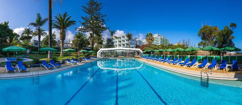 拉克鲁斯派克度假艾顿酒店的一个带椅子和遮阳伞的大型游泳池