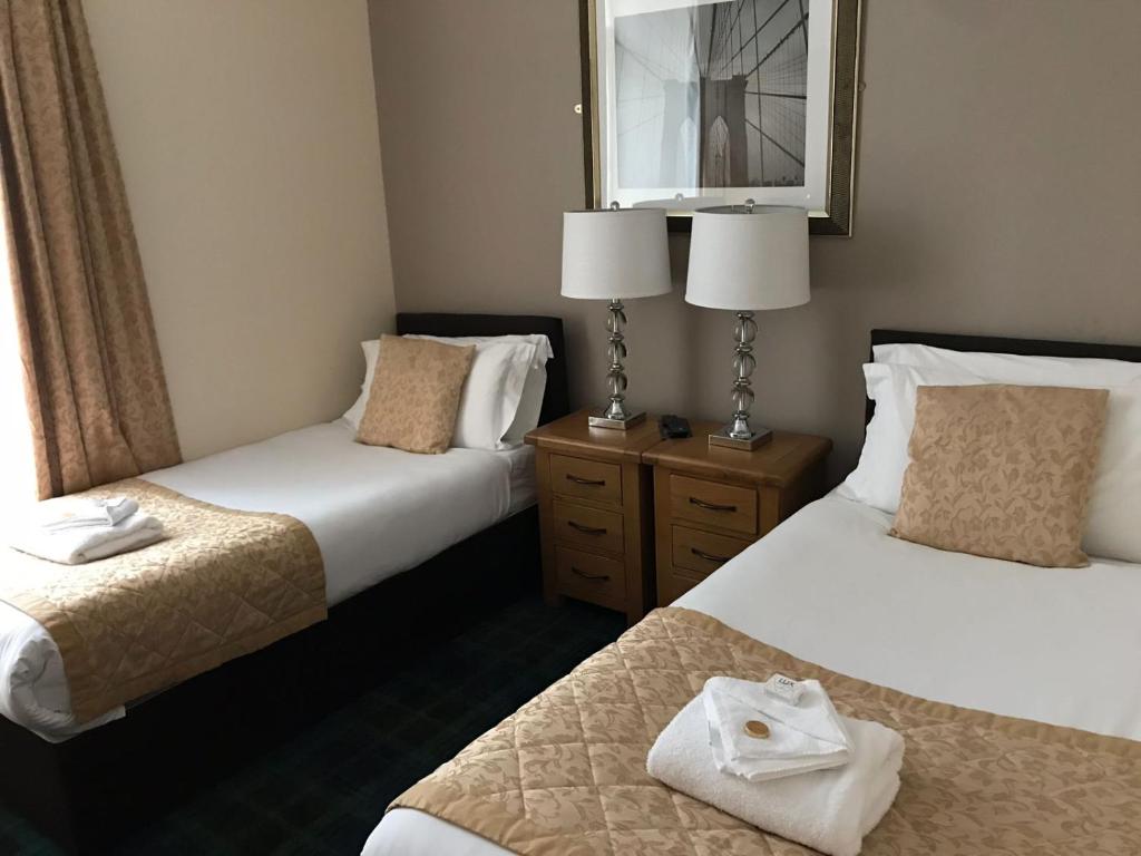 因弗内斯The Waverley Guest House的酒店客房,设有两张床和镜子