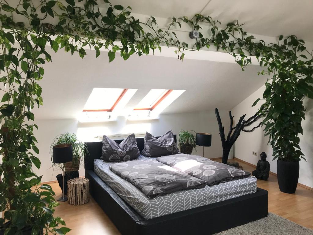 科特布斯Stadtdschungel FeWo mit Balkon的植物间内一间卧室,配有一张床