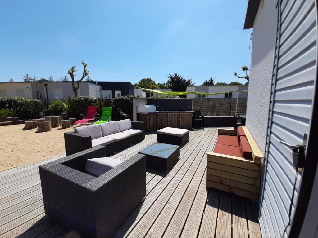 圣让-德蒙CLOS DE L'OCEAN 2 - maison 3 chambres à 300 m de la plage的木制甲板上配有沙发和椅子的庭院
