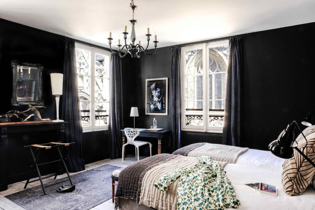 索姆河畔的圣瓦列里奥维尔斯佩德旅馆的一间卧室设有黑色的墙壁、一张床和一张书桌