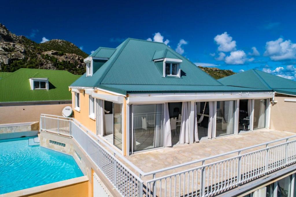 Saint Barthelemy2 bedrooms villa at Saint Barthelemy 500 m away from the beach with sea view private pool and terrace的一座带游泳池和绿色屋顶的房屋