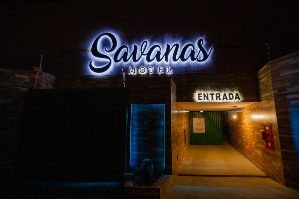 蓬塔格罗萨Savanas Motel的建筑物一侧的 ⁇ 虹灯标志