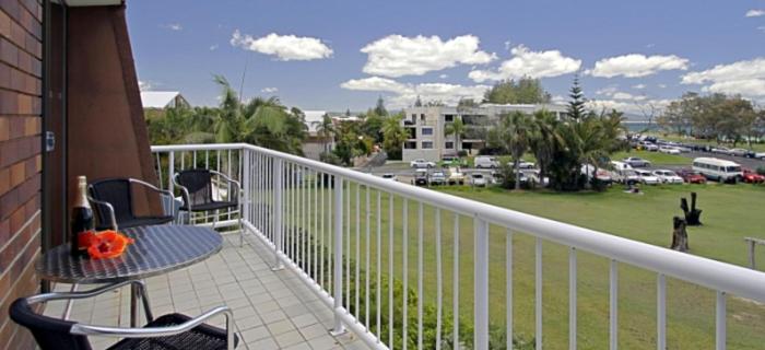 拜伦湾主海滩公寓 的一个带桌椅的阳台和一个停车位