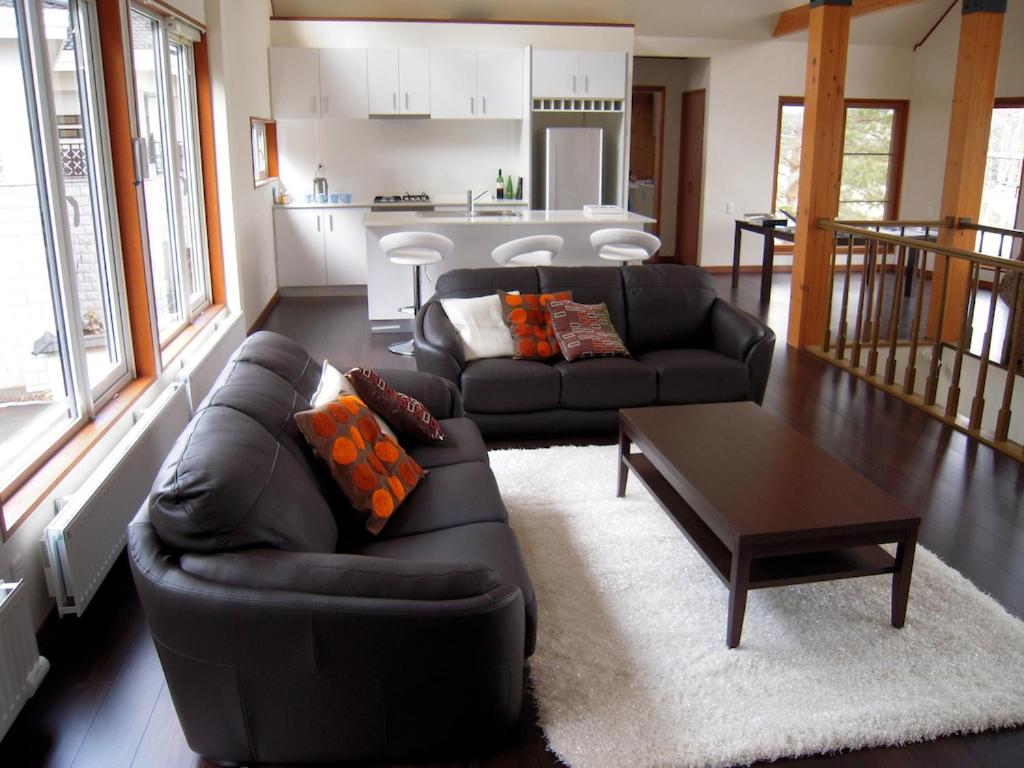 富良野Furano Lodge 10的客厅配有沙发和桌子
