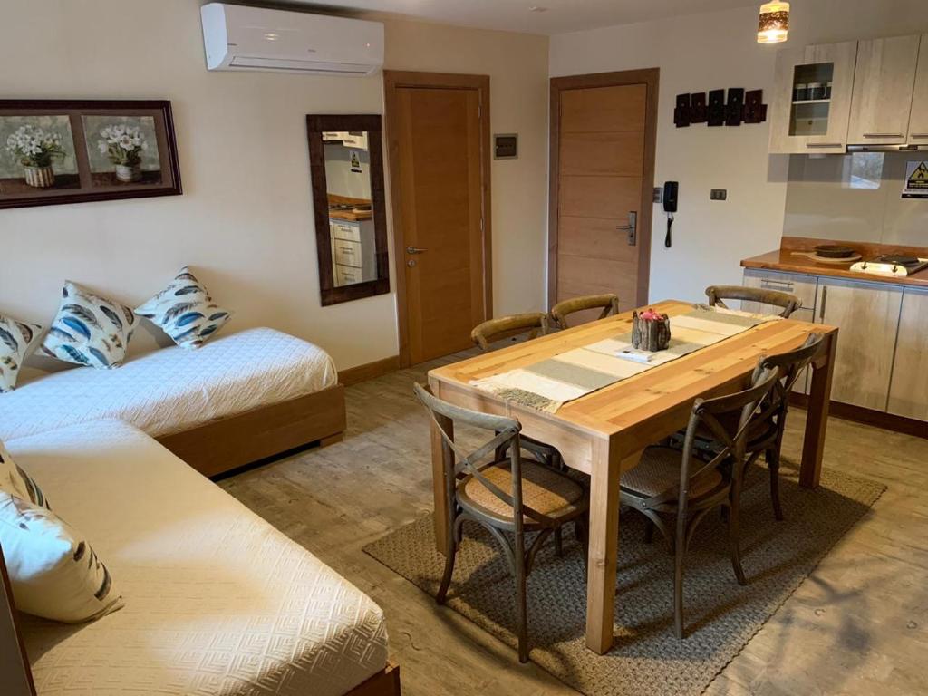 科伊艾科Entre Cumbres Hotel & Apart Hotel的一间设有桌子和床的房间和一间厨房