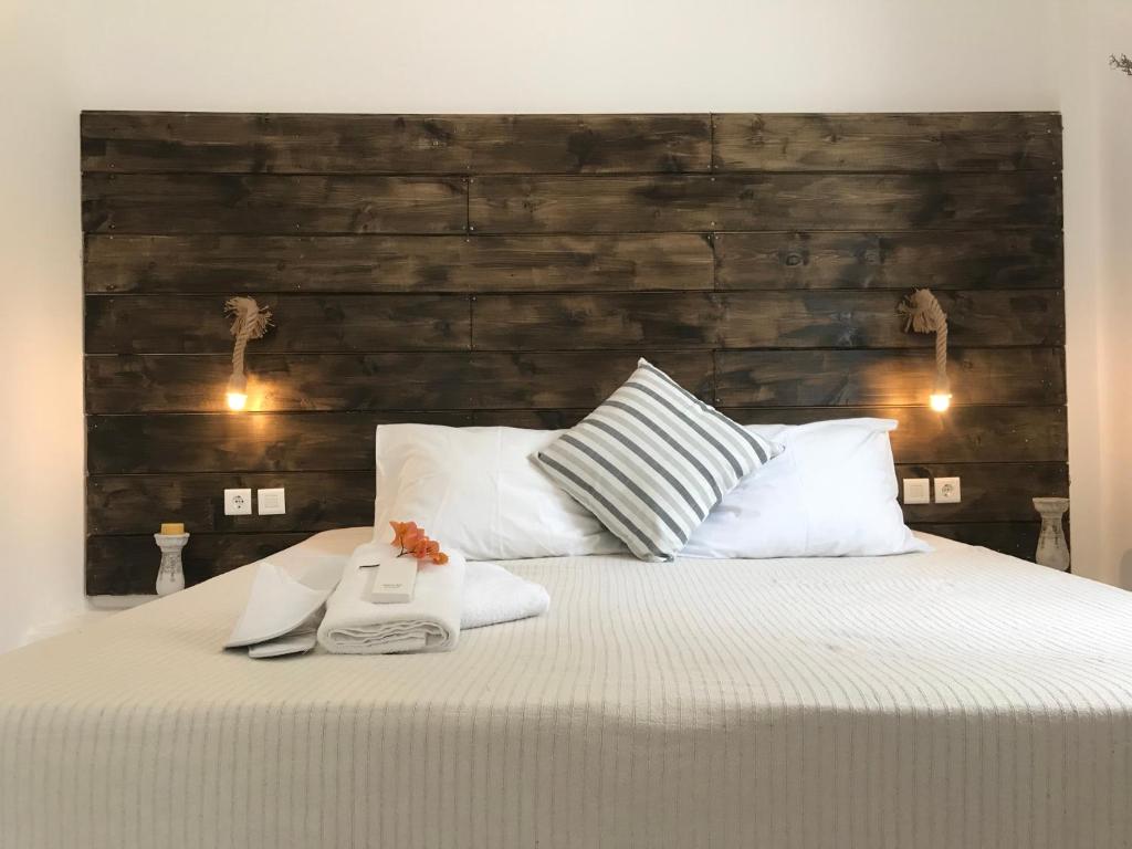 艾丽奇Ammos Luxury Studios的一间卧室配有一张大床和木制床头板