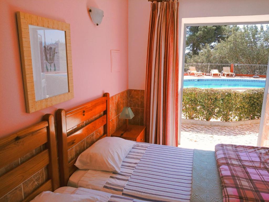 拉戈斯金塔多斯卡拉克丝酒店的一间卧室设有一张床和一个带游泳池的窗户