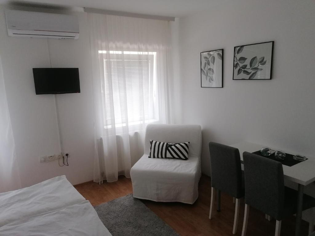 沙巴茨Veliki Park的白色的房间,配有椅子、桌子和电视