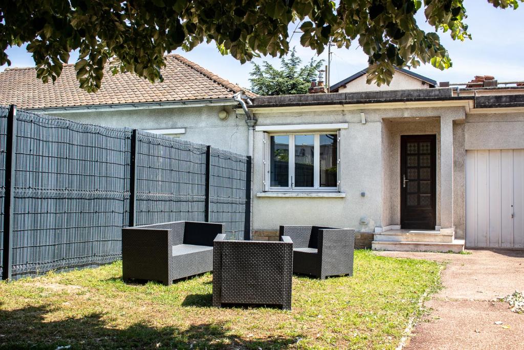 布隆Maisonnette avec jardin, parc du chêne (tram T5)的一座带三把椅子和围栏的房子