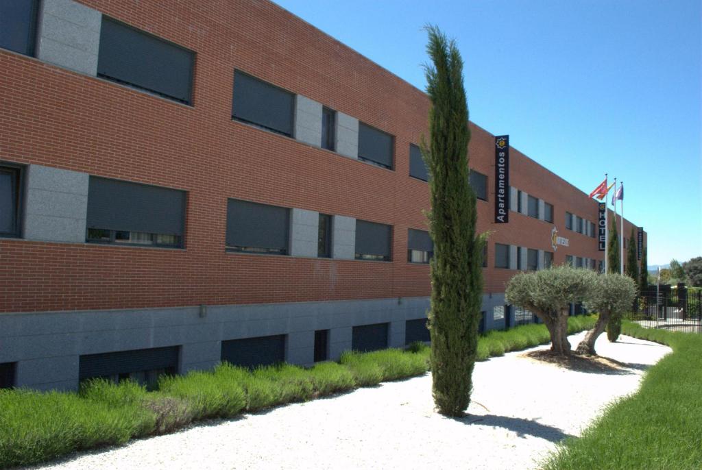 拉斯·罗萨斯·德·马德里塔尔特索斯公寓式酒店的前面有两棵树的红砖建筑