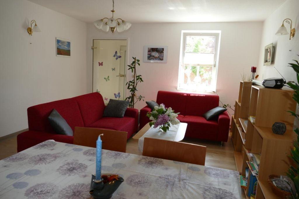 卑尔根Ferienwohnung-Amsel-kinderfreundliche-Unterkunft-in-zentraler-Lage的客厅配有两张红色的沙发和一张桌子