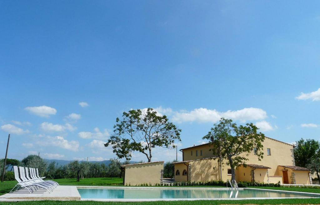 梅尔卡特勒瓦尔迪佩萨德诺西德尔泰努塔乡村民宿的一座带两把椅子的游泳池以及一座建筑