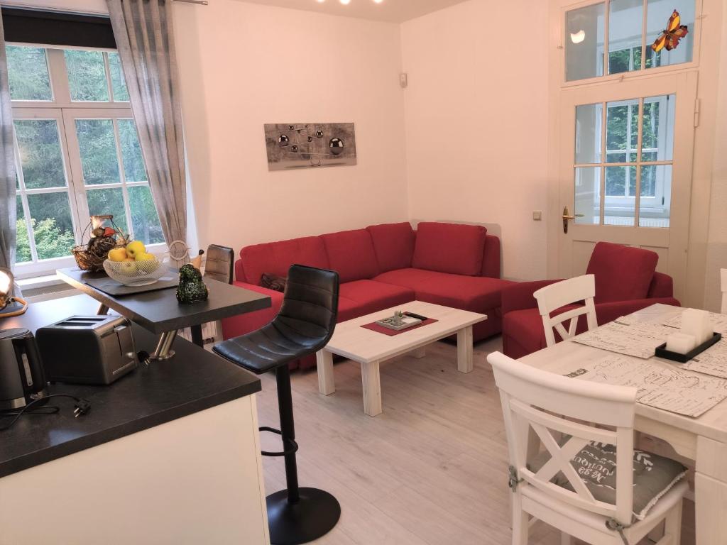 BielatalFerienwohnung Sächsische Schweiz的客厅配有红色的沙发和桌子