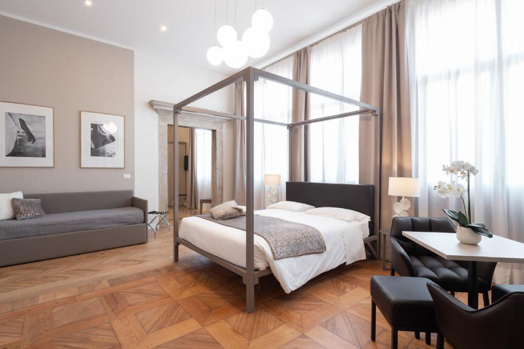 威尼斯Hotel Palazzo Martinelli Dolfin的一间卧室配有一张床、一张桌子和一张沙发