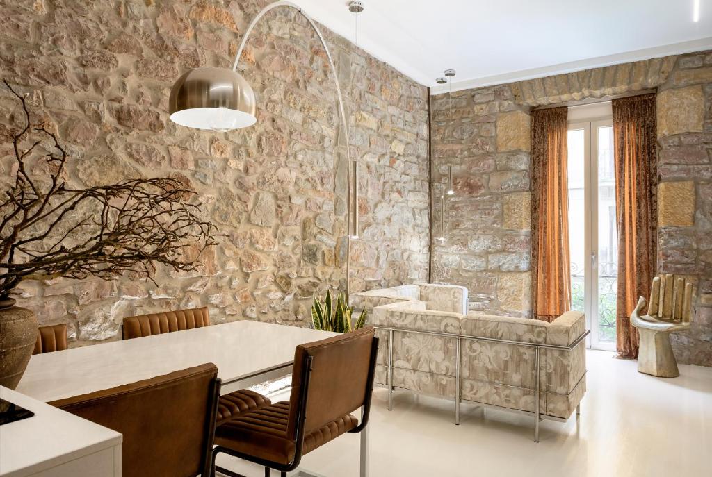 圣塞瓦斯蒂安Spectacular by Sebastiana Group的一间设有桌子和石墙的用餐室