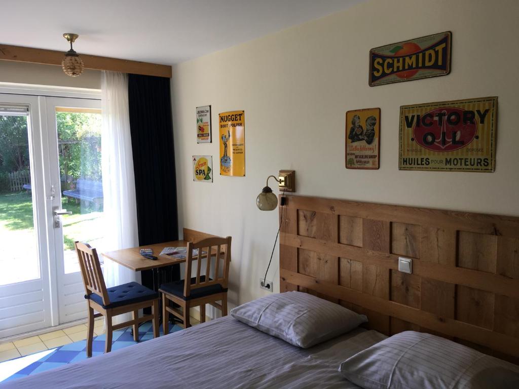 德科赫Carels Kamers Texel的一间卧室配有一张床、一张桌子和一张桌子
