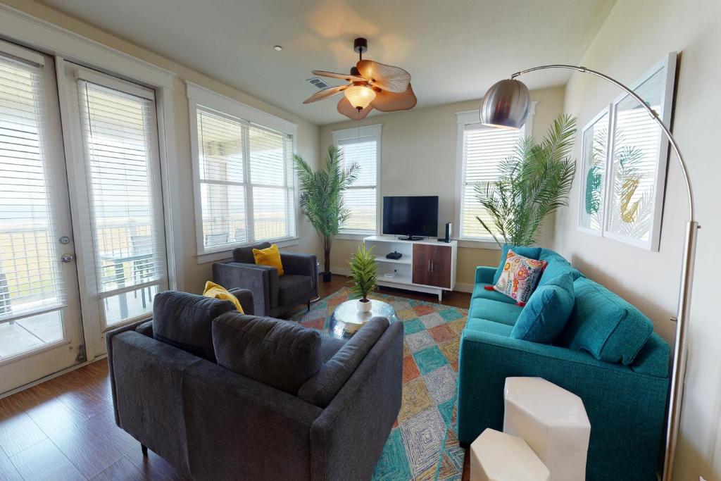 加尔维斯敦Ocean Breeze的客厅配有2张蓝色沙发和电视